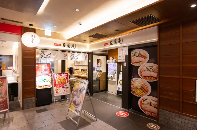 白い暖簾と花の模様が目を引く店舗入口